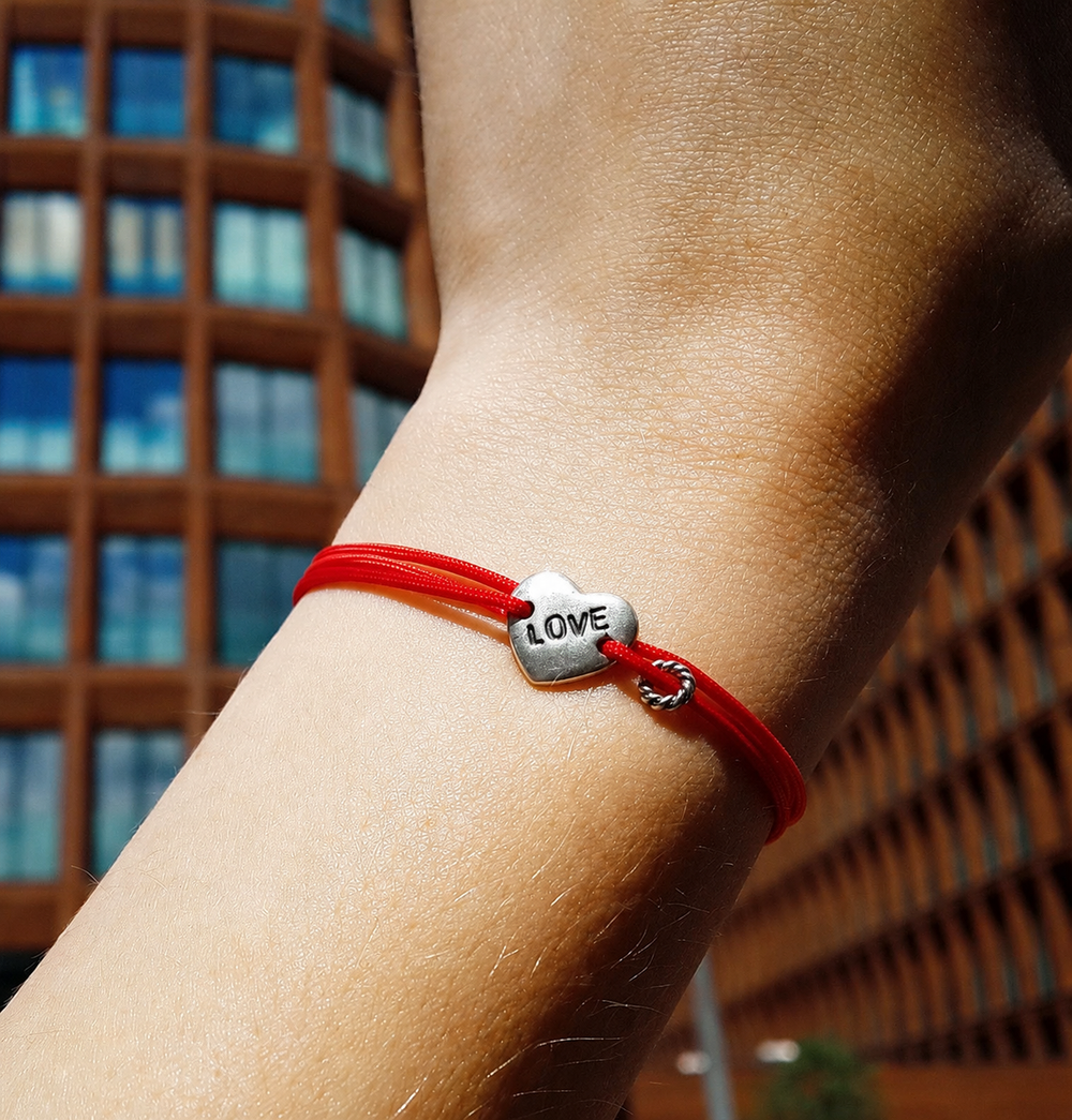 Love Bracelet on a red cord, worn on the wrist in the city
