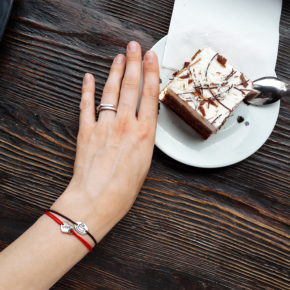 Love Bracelet worn every day — a hand resting by a coffee table