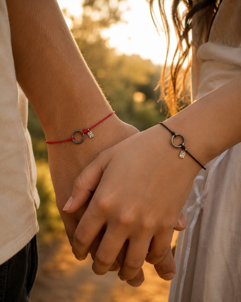 Two Ouroboros Bracelets on a couple’s hands at sunset
